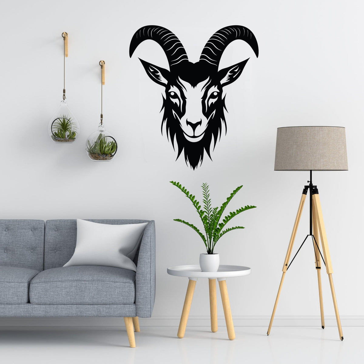 Bold black goat head silhouette wall sticker above a modern grey couch in a stylish living room.