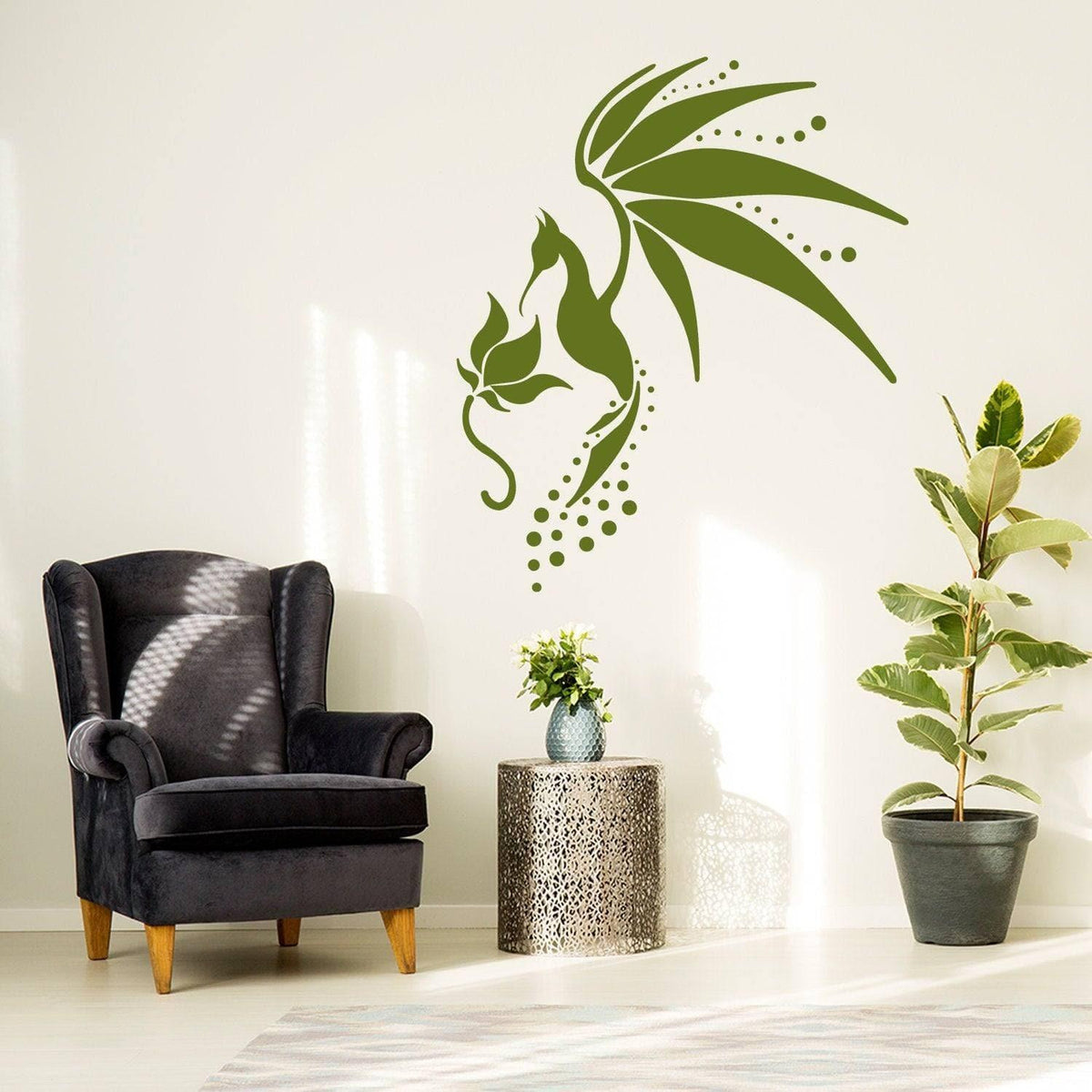 Green hummingbird wall decal above a modern chair and plant, adding decorative flair to home decor.