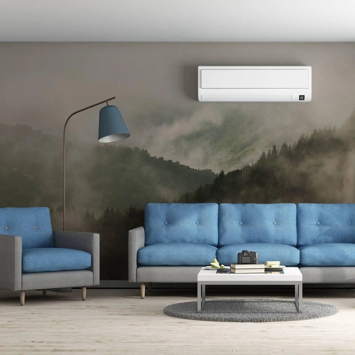 Elegant living room featuring Misty Pine Hill wallpaper mural with foggy forest design, blue couch, and modern lamp.