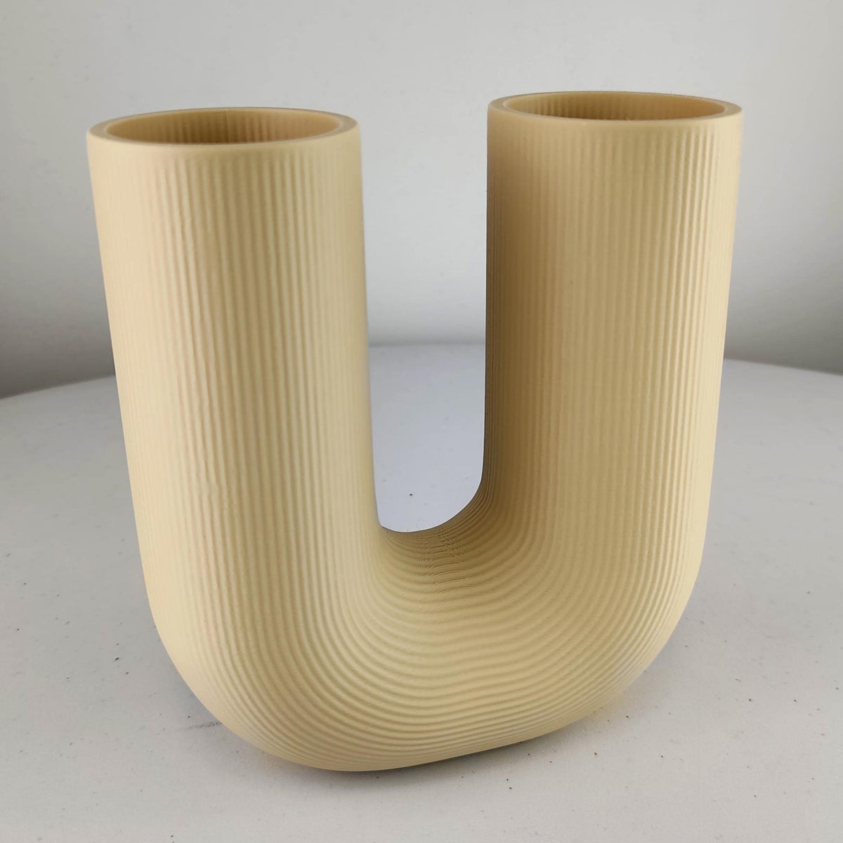 U Shaped Sculptural Vase featuring ribbed texture, styled with dried grasses for illustration; flowers are not included