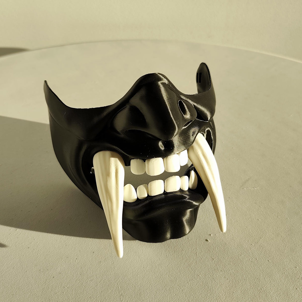 3D printed two color oni half face mask with contrasting fangs and a fierce demon expression