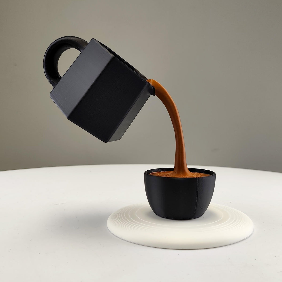 Floating Coffee Pour Sculpture featuring one cup suspended above the other