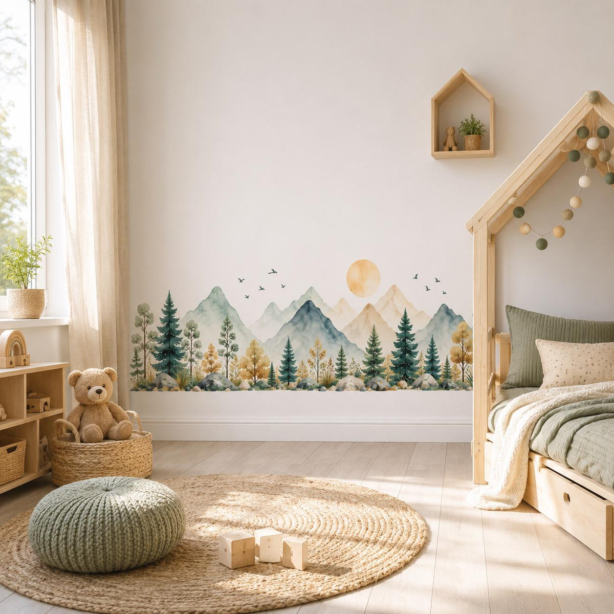 Watercolor mountain forest wall sticker beside a house-frame children's bed, window and green pouf.