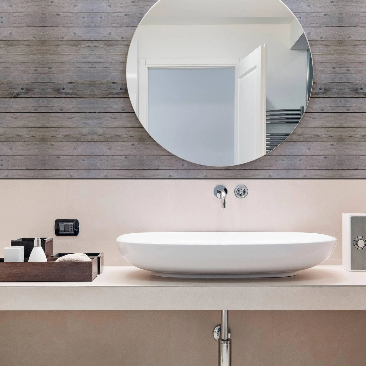 Modern bathroom featuring a rustic wooden plank wall decal and a sleek round mirror above a stylish sink.