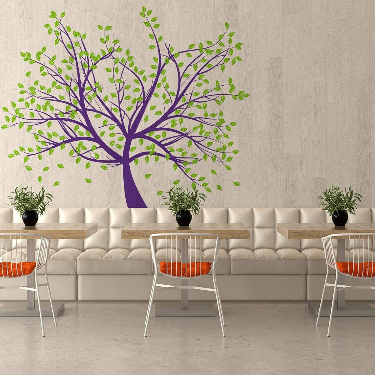 Tree wall decal in purple and green decorates a modern café with white seating and orange accents.