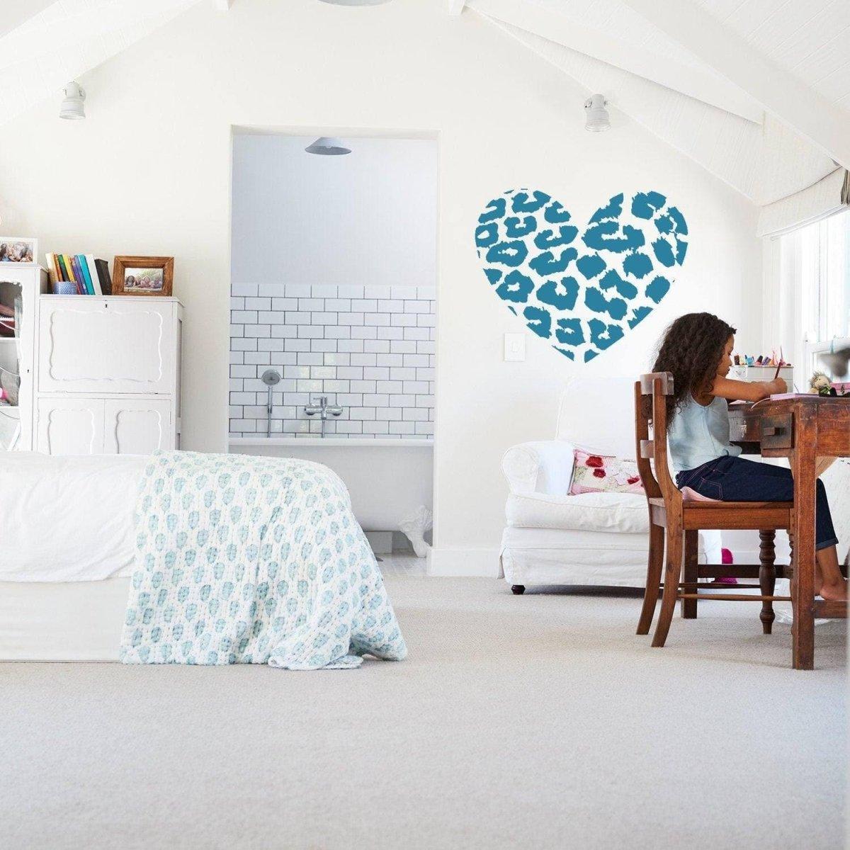 Cozy room featuring a girl at a table with a leopard heart vinyl wall art decal in a bright, aesthetic setting.