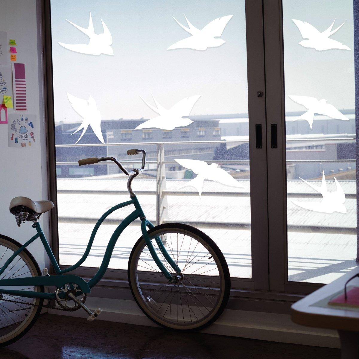 Window decal set with bird silhouettes on glass, enhancing aesthetics and preventing bird strikes.