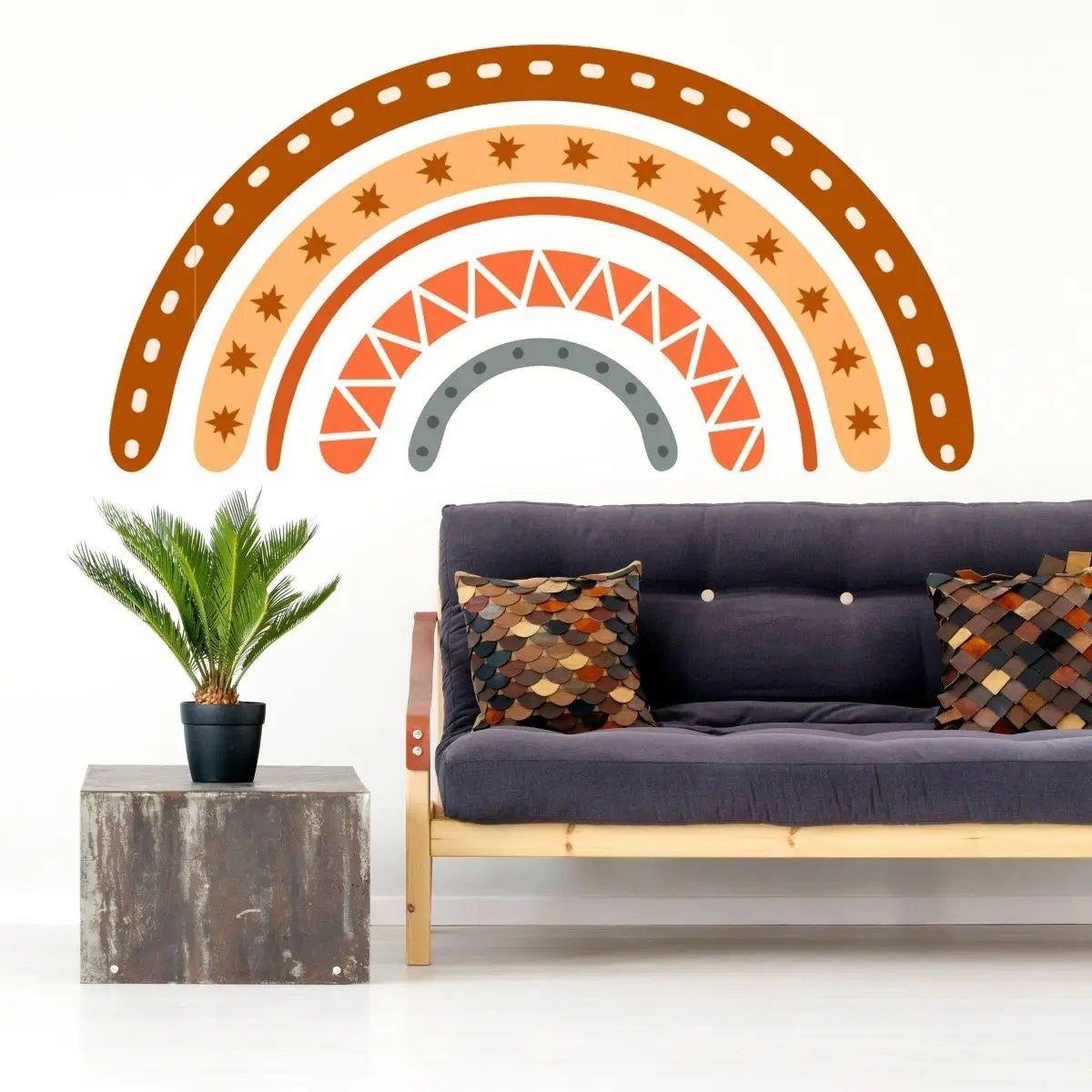 Boho chic rainbow wall decal above modern sofa with colorful pillows and a potted plant, adding charm to the living space.
