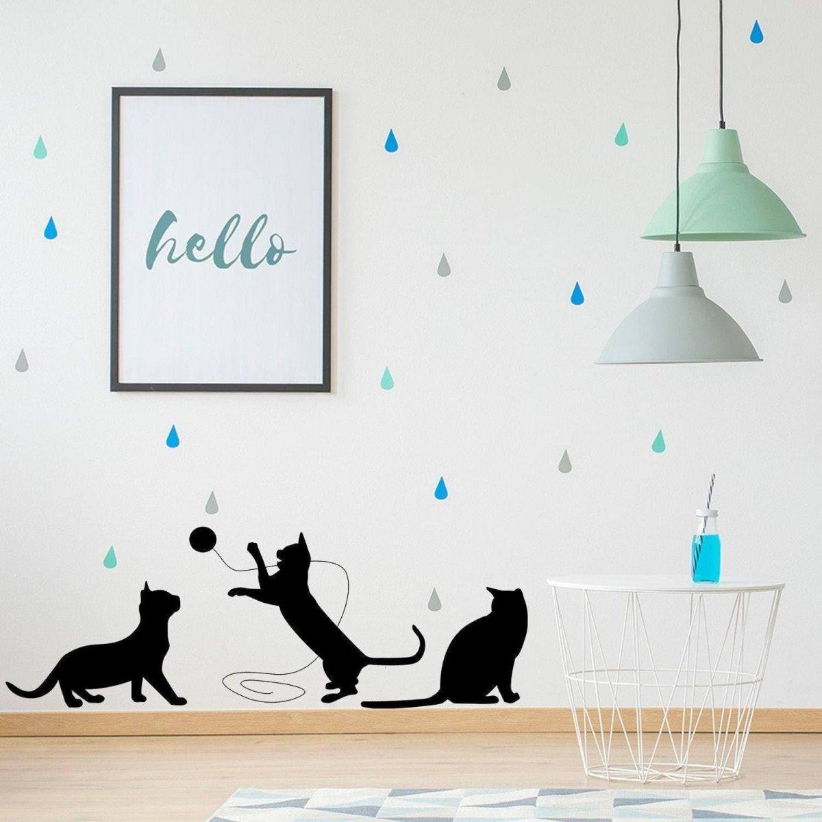 Adorable cat silhouette vinyl decal on a modern wall with playful raindrop designs and a decorative frame.