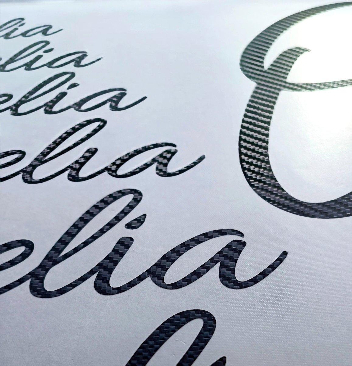 Personalized carbon fiber letter stickers featuring a stylish monogram design on a white background.