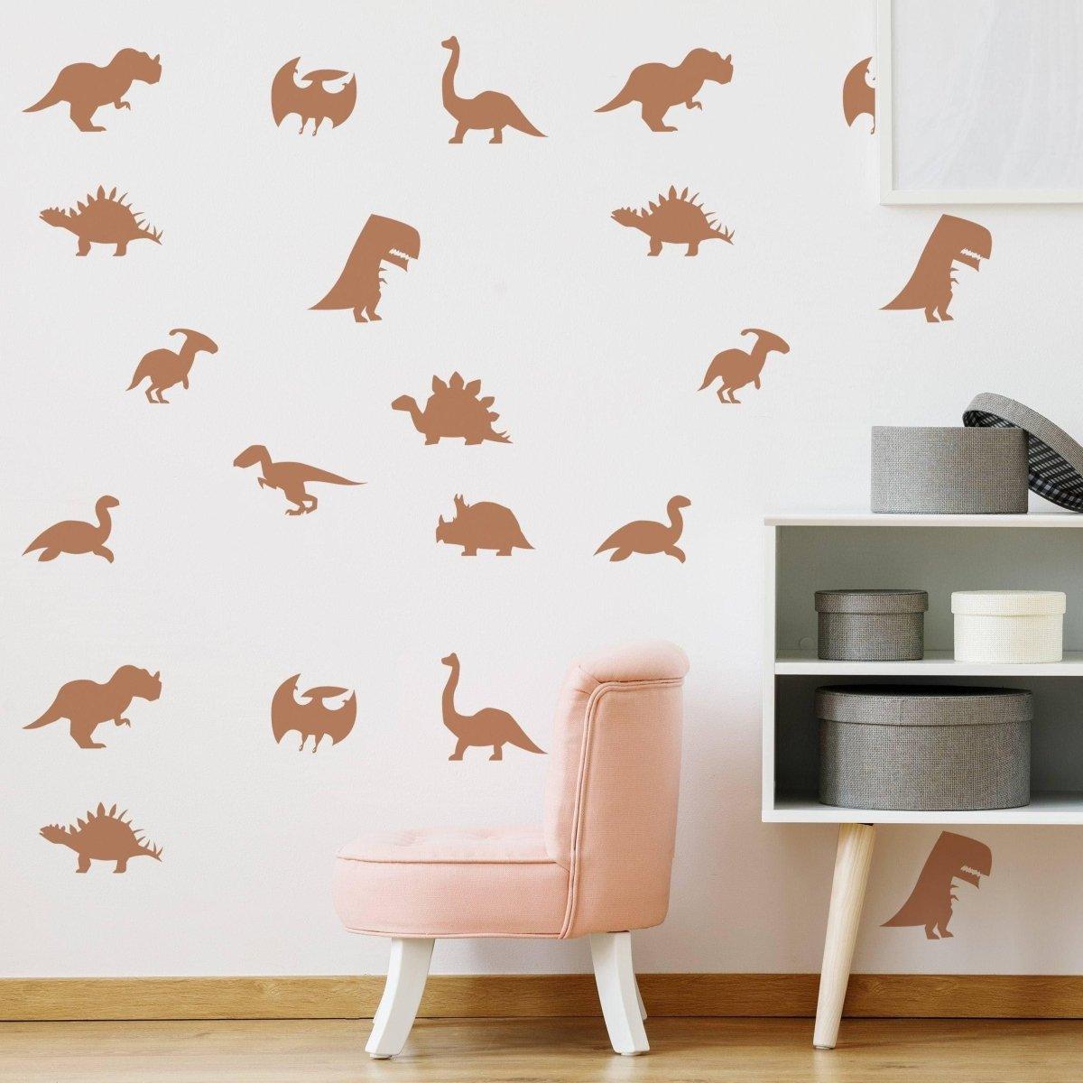 Dinosaur Dreams Wall Sticker Set featuring various dinosaur silhouettes on a wall with a cute pink chair.