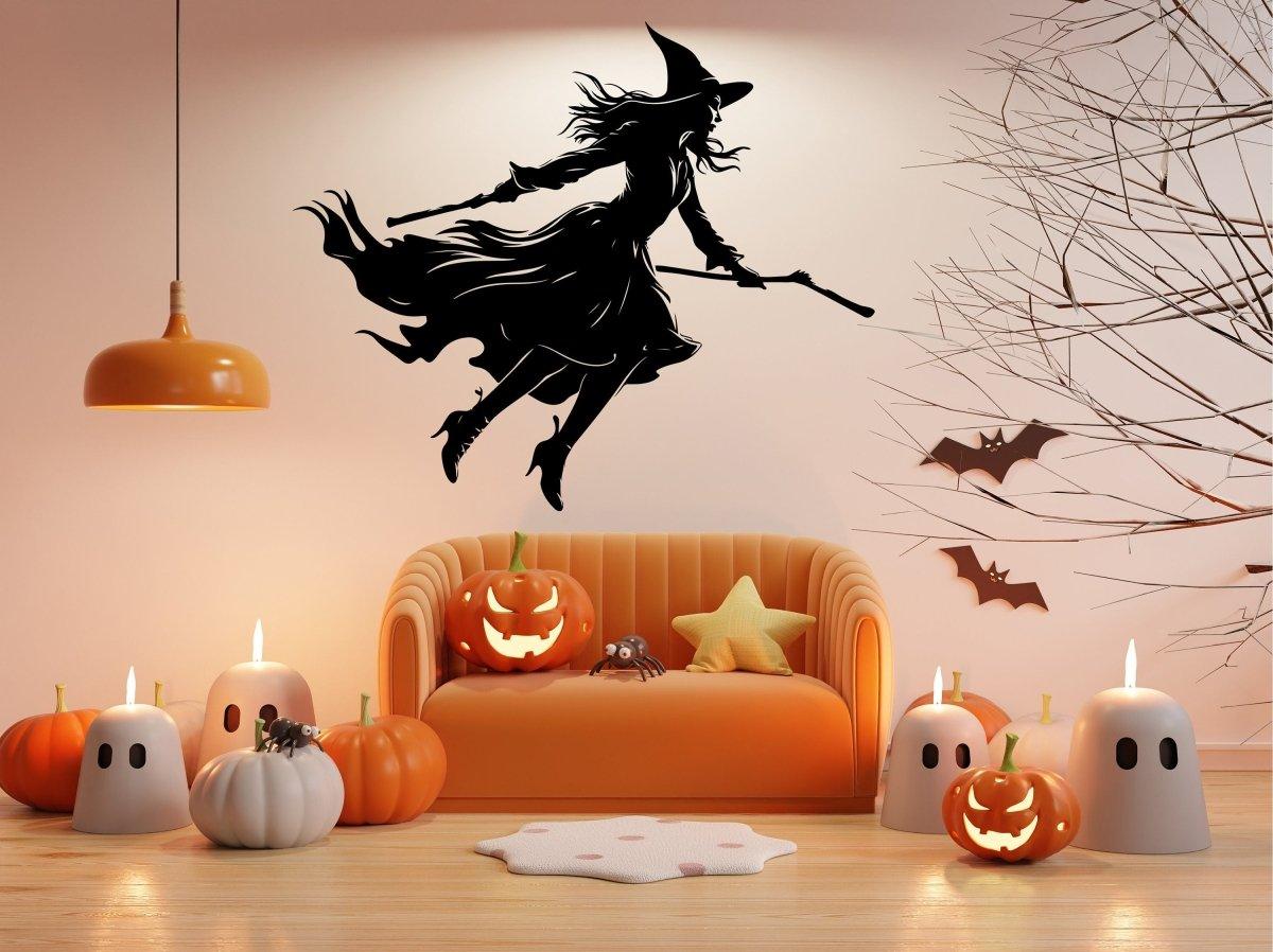 Flying broom figure silhouette wall decal displayed above a sofa.