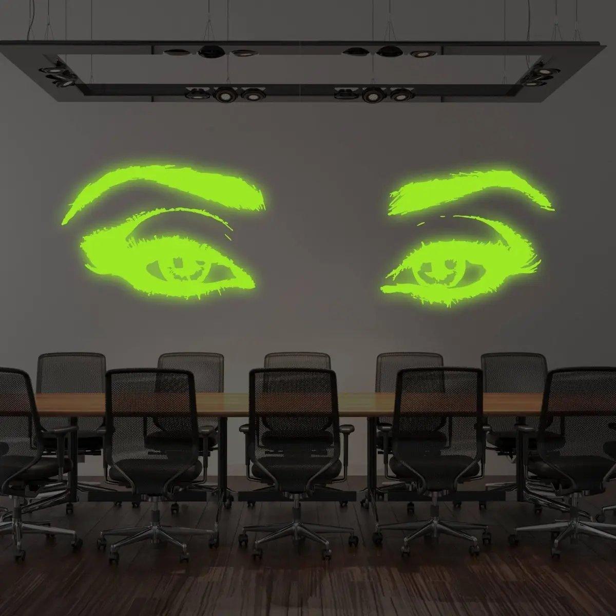 Glowing luminescent woman eye vinyl wall decal in a modern conference room setting.