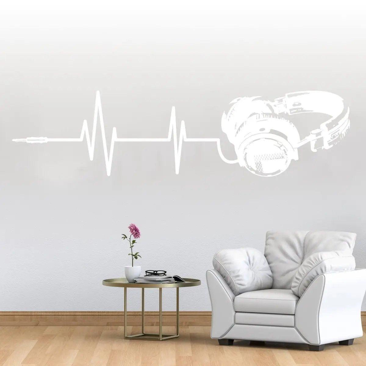 Vinyl wall decal of headphones with sound wave design in a modern living room setting.