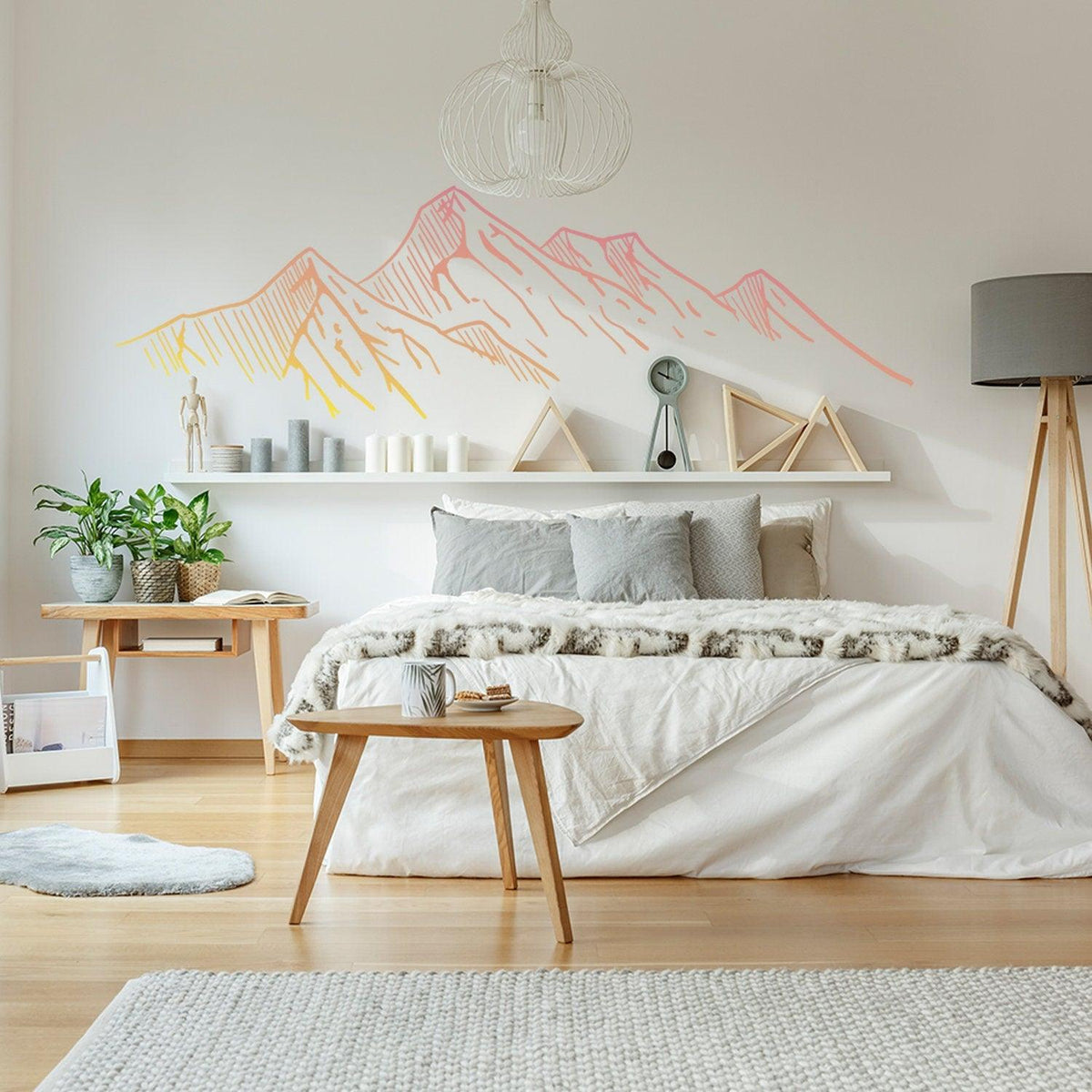 Mountain silhouette wall decal in a cozy bedroom with modern decor and a bed with gray and white bedding.