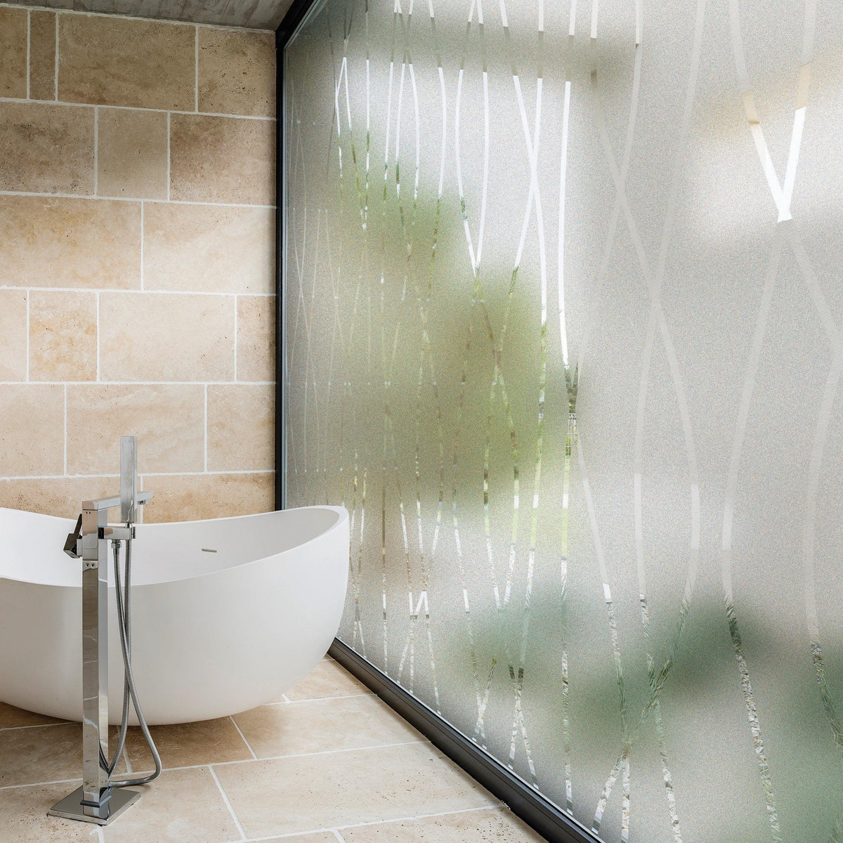 Frosted glass window vinyl sticker on a glass wall in a modern bathroom with a bathtub.