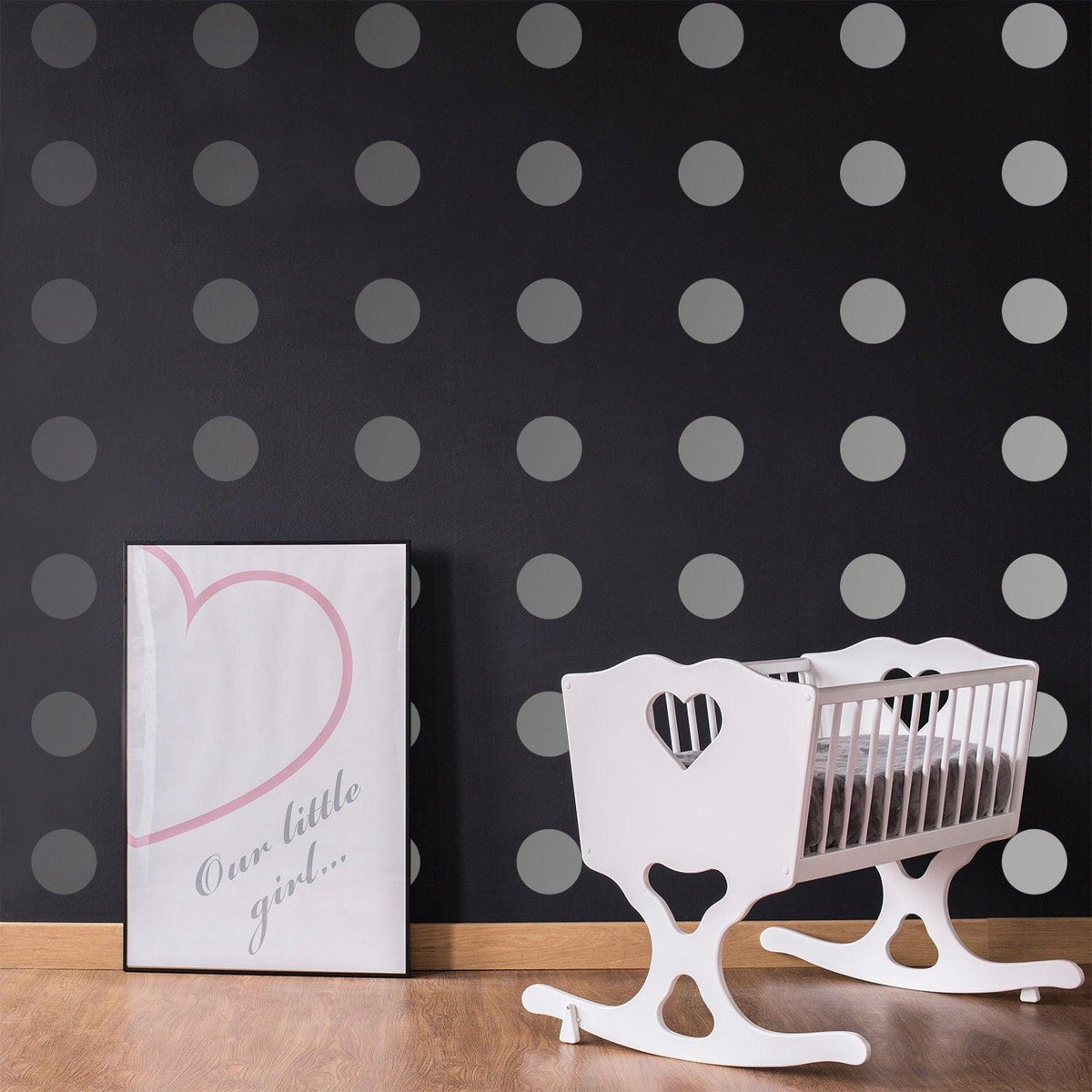 Stylish nursery featuring gray circle wall decals, a white rocking crib, and framed decor for a chic look.