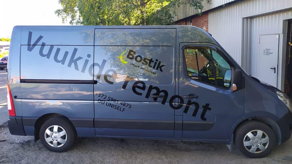 Custom business vinyl graphics displayed on a grey van.