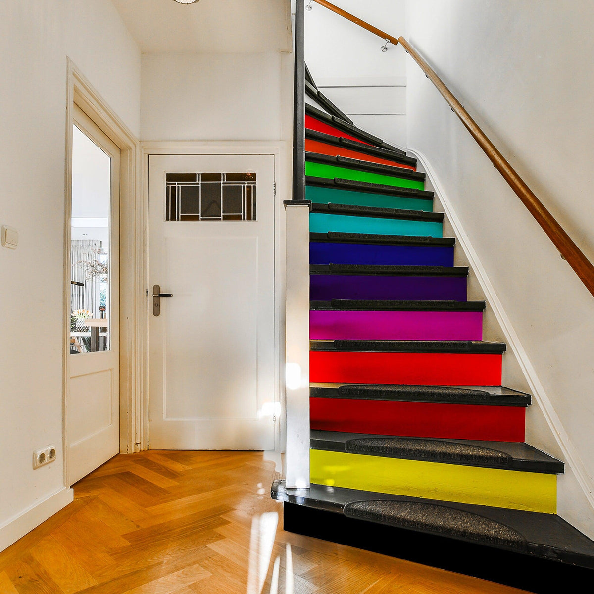 Colorful rainbow staircase with self-adhesive risers stickers adding vibrancy to the home decor.