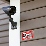Video surveillance camera mounted on wall with warning sign, ensuring property security and monitoring.