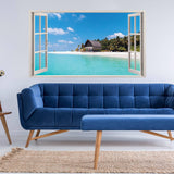 Tropical paradise window sticker showcasing a beach view with a blue couch and natural decor in a modern living room.