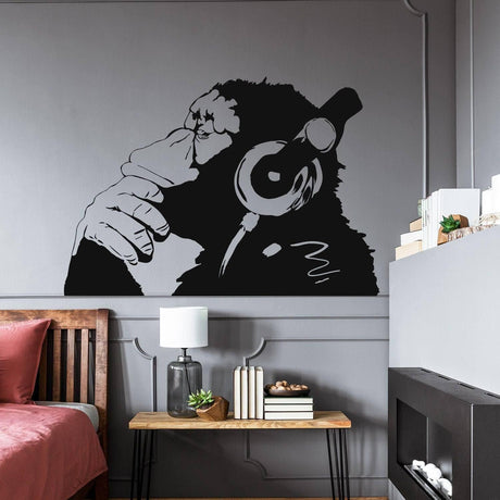 Contemplative primate wall art sticker featuring a monkey with headphones in a stylish room setting.