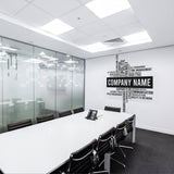 Modern office conference room featuring a personalized company name wall decal and sleek, minimalist furniture.