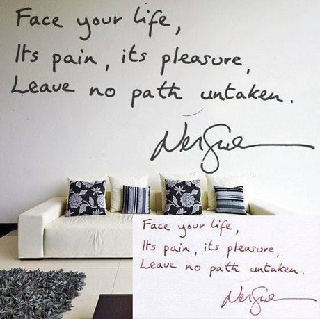 Inspirational handwritten quote wall decal on display above a modern sofa with decorative pillows.