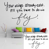 Personalized wall decal with inspiring quote 'Your wings already exist. All you have to do is fly.' near a colorful couch.