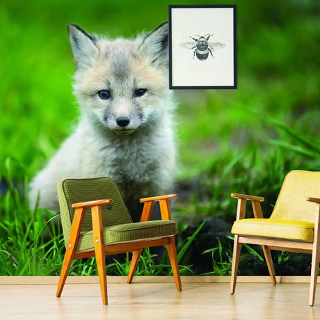 Whimsical fox wall art in a nursery with green grass and modern chairs.