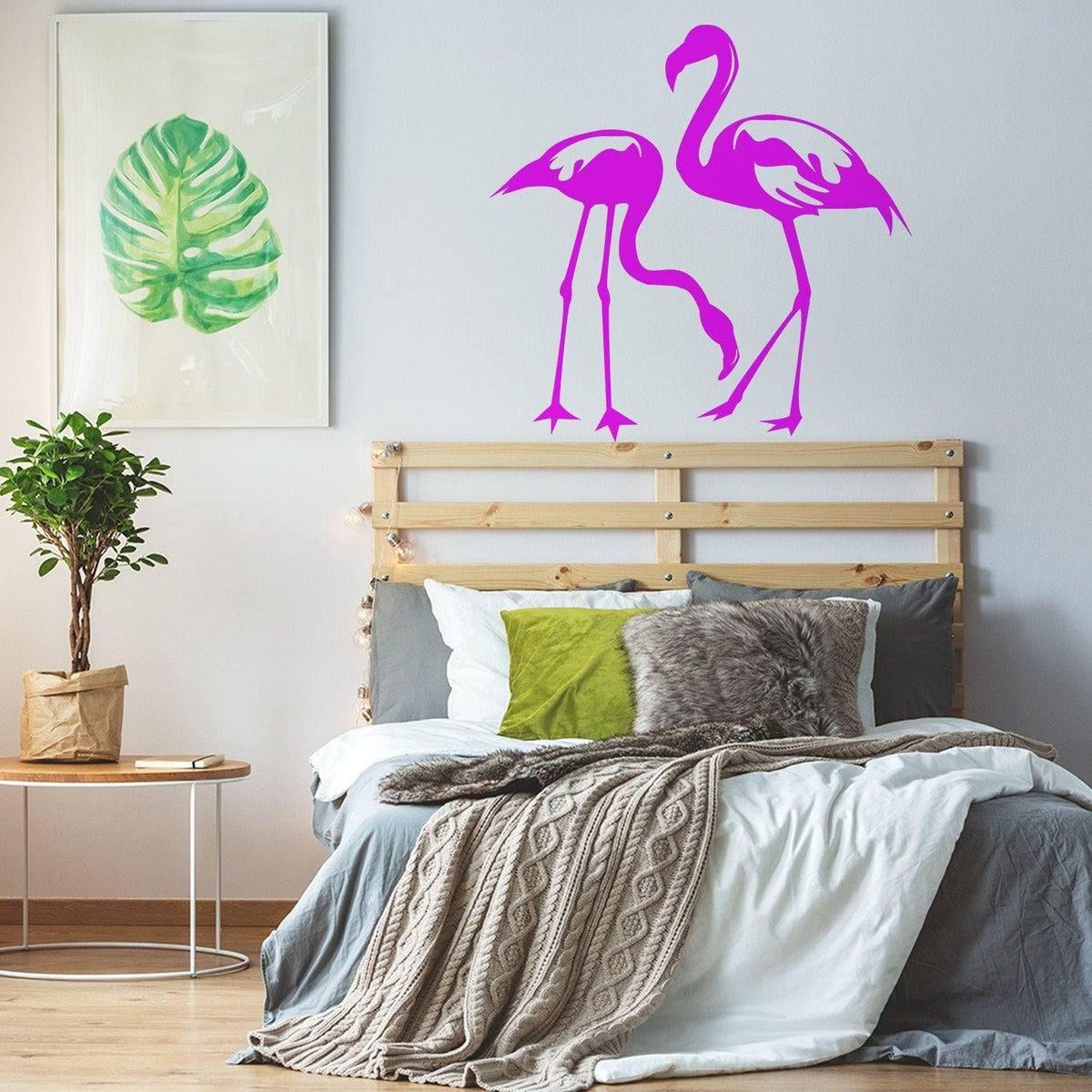 Pink flamingo wall decals above bed in a modern bedroom with tropical decor.