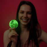 Smiling woman holding a glowing green moon decoration against a pink background, showcasing a fun laptop decal design.