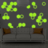 Glow in the dark hexagon wall stickers decorating a room with a modern sofa, adding a whimsical touch to children's spaces.