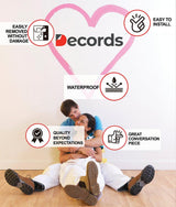 Couple sitting beside an inches growth chart wall decal product features graphic.
