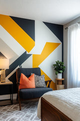 Custom geometric wall decal in living room featuring bold black, yellow, and white patterns with modern furniture.