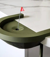 Interactive desktop golf game with a putting green and flag on a white table.