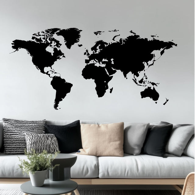 Modern black vinyl world map wall decal in a stylish living room setting.