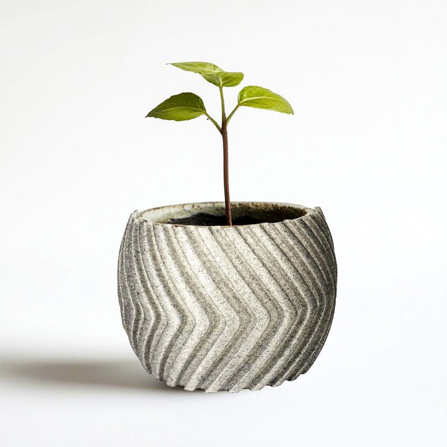3D printed modern zig zag planter cover with a small green plant, enhancing minimalist indoor decor.