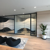Modern office interior featuring a wave design frosted glass privacy sticker on partition with black seating.