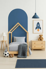 Kids room featuring a modern arch wall decal in blue, a wooden bed frame, and playful decor elements.