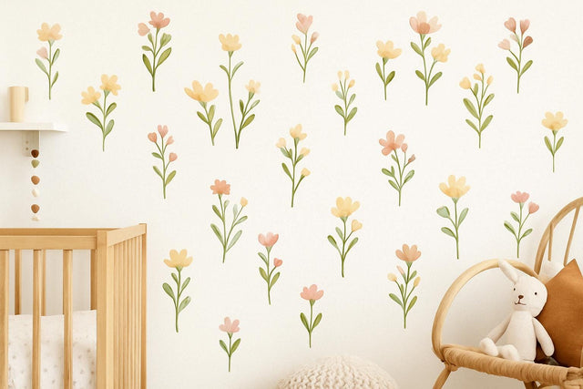 A nursery wall decorated with soft pastel flower decals in peach, blush, and yellow tones.