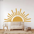 Large half sun wall decal in a nursery, featuring a minimalist design with yellow tones, adding warmth to baby room decor.