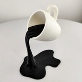 Floating Coffee Cup Sculpture featuring suspended pouring stream and spill shaped base