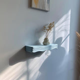 3D printed Organic Wave Wall Shelf with ripple shaped support holding a decorative vase