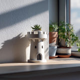 Miniature castle tower planter displayed with a small succulent