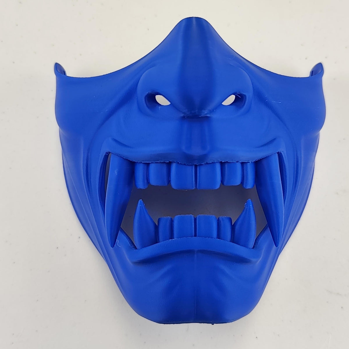 Oni Samurai Half Face Mask featuring fierce fangs and intricate detailing, worn by a man in a dark shirt