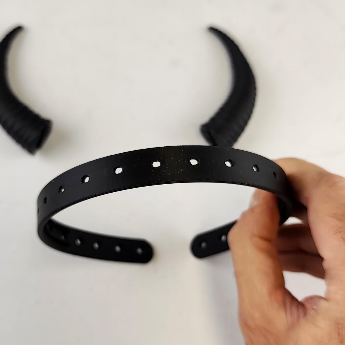 Product illustration of subtle curved demon horns headband with a coordinated pair of textured curved horns mounted on a lightweight band