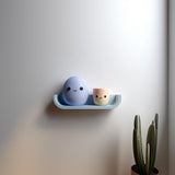3D printed Egg Friends Wall Shelf with rounded ledge holding a smiling egg character and a small cup character