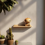 Sun Critter Wall Shelf featuring small sun like character sitting on a slim tray style ledge