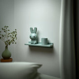 3D printed Bunny Buddy Wall Shelf with slim back edged ledge holding a rounded bunny character and a cylinder pot